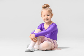 Cute little ballerina on light background