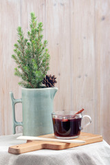 A cup of homemade mulled wine and a small Christmas tree on the coffee table