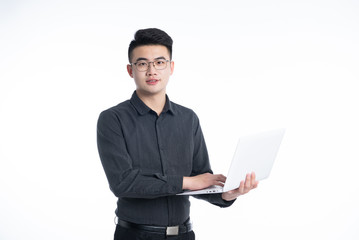 A young Asian man is using his mobile phone and laptop