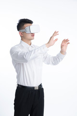 A young Asian man is using his mobile phone and laptop