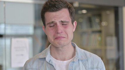 Obraz premium The Portrait of Upset Young Designer Crying at Camera