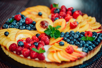 Fototapeta na wymiar Classic simple new York cheesecake with berries and fruit, close-up view, selective focus