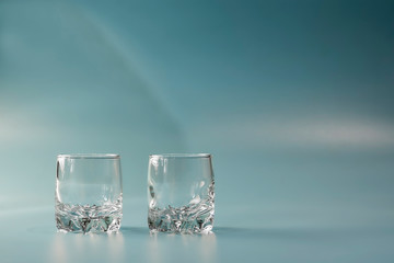 Two empty glasses on a blue background