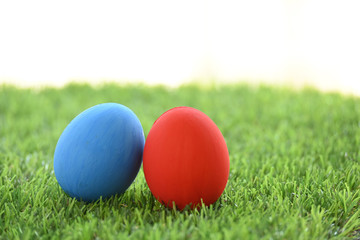 blue and red easter egg on lawn green grass artificial with blank white background