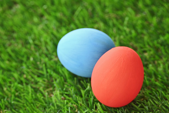 red and blue easter egg on lawn green grass artificial, concept image of morning in springtime