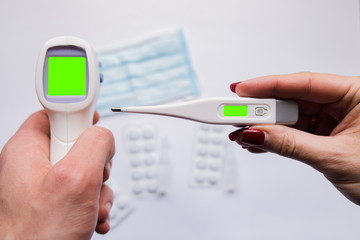 two electronic thermometers in hands