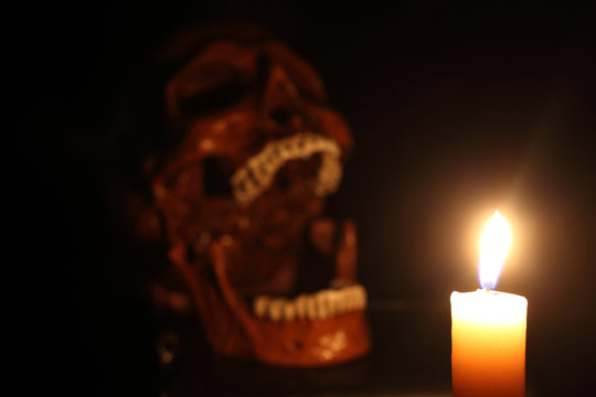 Skull and candle. Focus on fire
