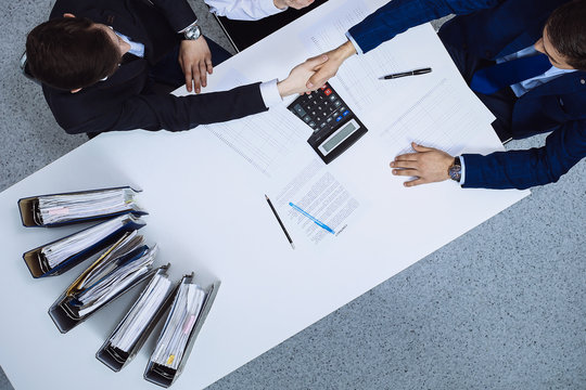 Business People Shaking Hands At Meeting, View From Above. Bookkeeper Or Financial Inspector Making Report, Calculating Or Checking Balance