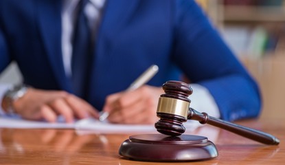 Handsome judge with gavel sitting in courtroom