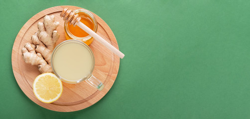 Ginger tea with honey and lemon on green background with copy space. Virus protection