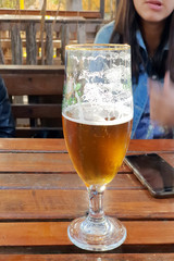 Young sexy oktoberfest girl, wearing a traditional Bavarian denim jeans clothing, watching big beer mug with drink.
