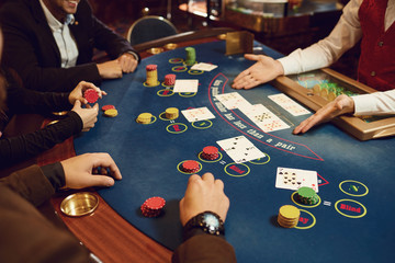 People gamble at a poker table in a casino.
