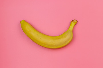Yellow banana on pink background. Top view, flat lay, minimal design