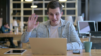 The Young Designer doing Video Chat on Laptop in Modern Office