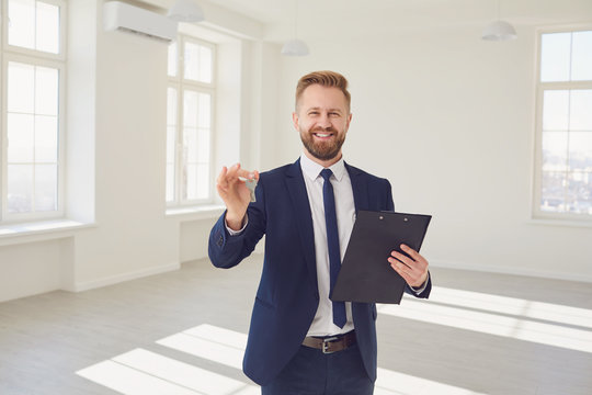 Cheerful real estate agent with key in new apartment
