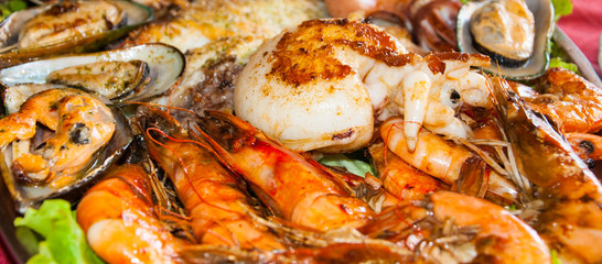 DolphGreat seafood platter, octopus, greens, shrimp, fish, mussels, grilled dishesin over the water in the pool on a background of blue water