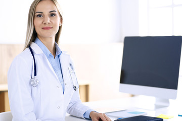 Woman doctor standing in hospital office. Physician at work, life portrait. Medicine and health care concept