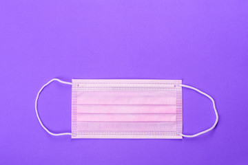 Medical mask on a colored background, a means of protection against coronovirus and epidemic