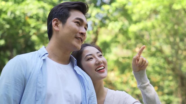 loving young asian couple talking a walk outdoors in park