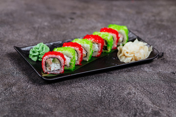 Various kinds of sushi served on black stone