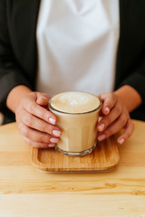 hands holding cup of coffee in coffee shop vintage color