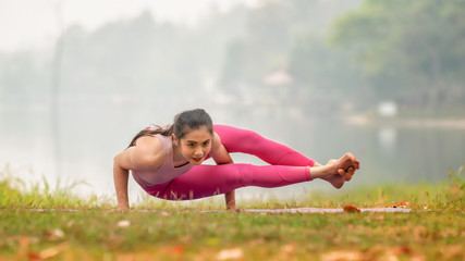 Naklejka na ściany i meble Young girl doing yoga fitness exercise outdoor