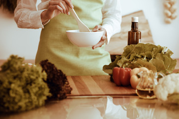 Unknown human hands cooking in kitchen. Woman is busy with vegetable salad. Healthy meal, and vegetarian food concept