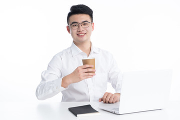 A young Asian business man stood behind his desk