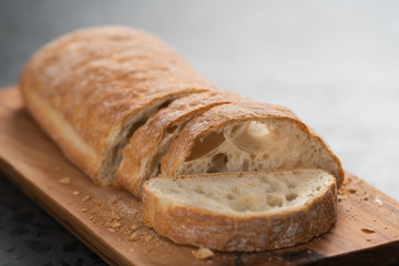 sliced freshly baked ciabatta bread on olive board