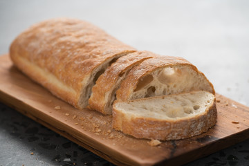 sliced freshly baked ciabatta bread on olive board