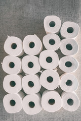 Toilet paper rolls background top flat view of many open rolls, vertical copy space. Hoarding of bathroom tissues in fear of store supply shor tage during coronavirus COVID-19 panic buying.