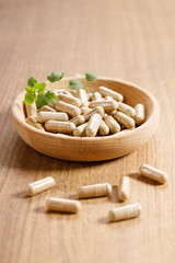 herbal pills on wooden background