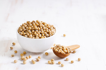 Closeup soy beans in ceramic bowl on white wooden table