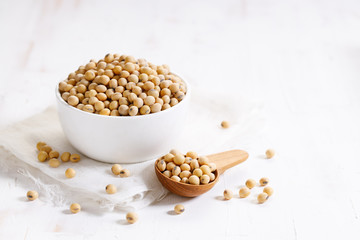 Closeup soy beans in ceramic bowl on white wooden table