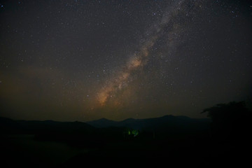Fototapeta na wymiar Landscape of the milky way galaxy with starlight over the mountain with tree at Kanchanaburi province,Thailand.