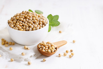 Closeup soy beans in ceramic bowl on white wooden table