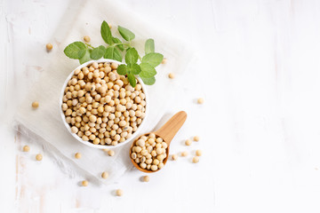 Closeup soy beans in ceramic bowl on white wooden table