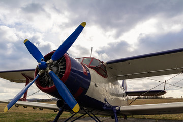 White biplane standing on airports with cloud sky