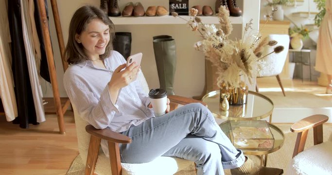 Brunette Girl Take A Coffee Break From Shopping In Show Room