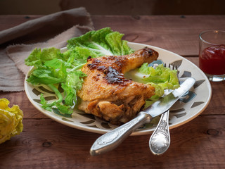 Grilled chicken leg with lettuce for a light bite with cutlery