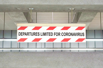 Information sign with the word "DEPARTURES LIMITED FOR CORONAVIRUS" on the empty railway platform