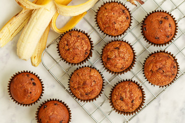 Homemade banana muffins with chocolate chips and salted caramel on a marble background. Delicious and healthy dessert for Breakfast. Selective focus, top view - obrazy, fototapety, plakaty