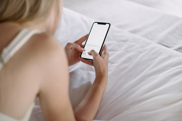Young adult woman spending morning in cozy bedroom