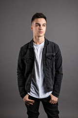 Fototapeta premium Young serious man posing in studio. Gray background