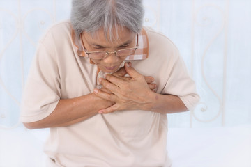 Senior heart disease concept; elders female suffering from the pain her chest, heart attack at home
