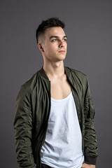 Obraz premium Young serious man posing in studio. Gray background