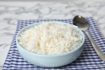 Bowl with tasty cooked rice on table, closeup