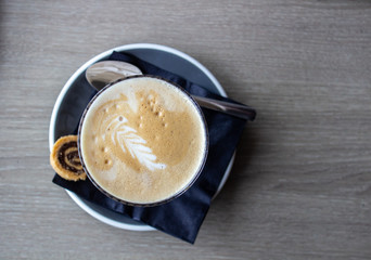 cappuccino cup on the brown wooden table.