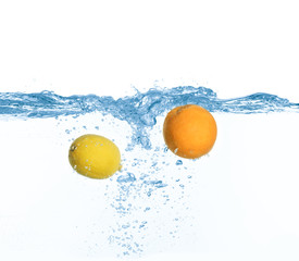 Fototapeta na wymiar Ripe orange and lemon falling down into clear water with splashes against white background