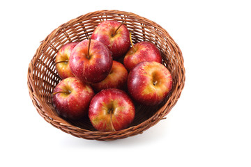 Red little apples on wicker plate